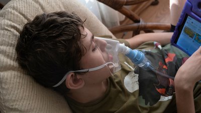 12 year old boy with special needs getting a nebulizer treatment for asthma