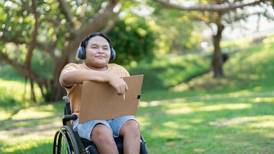 Asian Boy in Wheelchair Enjoying Art in Nature