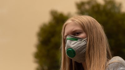 Australian bushfire blond girl wearing P2 N95 protection respiratory mask from bushfire smoke