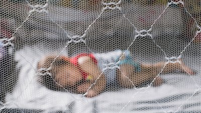 Baby sleeping under a mosquito net