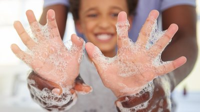 Black family, washing hands and soap foam with a father and child in a bathroom with a smile