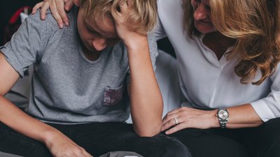 Boy being comforted by his mother