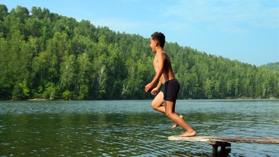 Boy jumping in lake