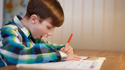 Boy writing in notebook