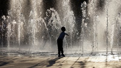 Child enjoying the summer hot weather in city