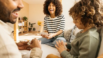 Family enjoying a playful and cheerful time together playing a card game in a bright living room