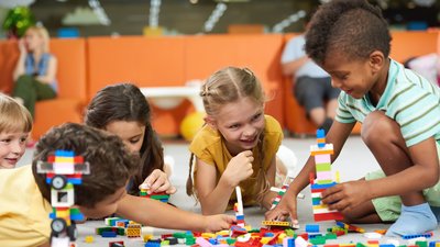 Group of funny kids playing with block toys indoor