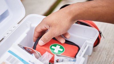 Hand Reaches Into First Aid Kit