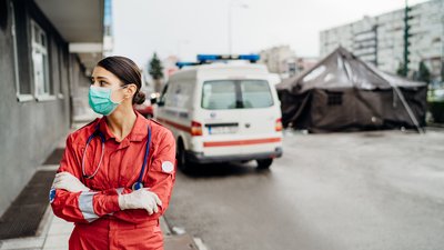 Healthcare worker in uniform in front of isolation tent