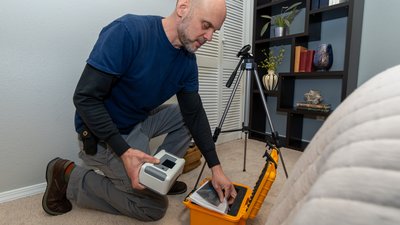 Home inspector doing a radon test setup in the lowest bedroom of a home