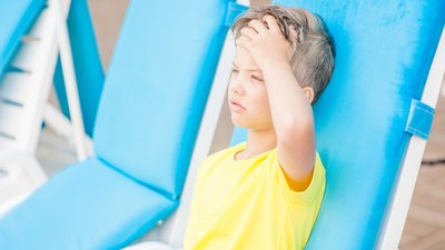 Little boy on the beach with a sunstroke