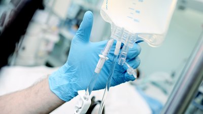 Medical worker regulate the intravenous drip system at the bedside