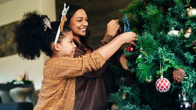 Mother, girl and bonding with christmas tree decoration in family home