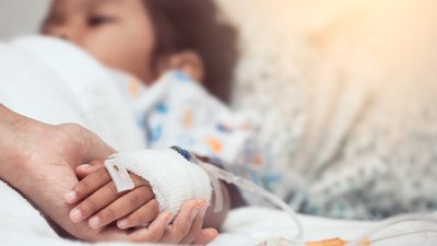 Mother hand holding child hand who have IV solution in the hospital with love and care