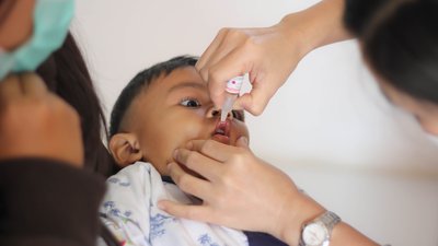 Nurse making infant oral vaccination against rotavirus infection