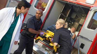 Paramedics and doctor unloading patient from ambulance