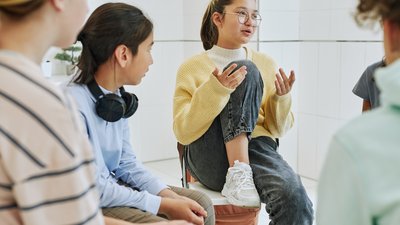 Portrait of teenage girl sharing feelings in support group circle for children
