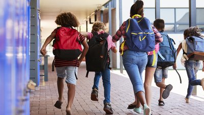 School kids running in elementary school hallway