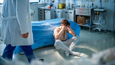 Teenage patient sitting on hospital bed, waiting for doctor