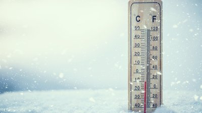 Thermometer on snow shows low temperatures under zero