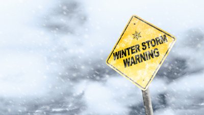 Winter Storm Warning Sign With Snowfall and Stormy Background