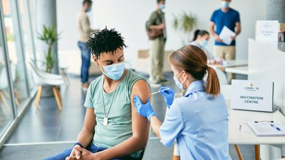 Young African American man getting vaccinated against coronavirus at vaccination center