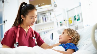 Young Girl Talking To Female Nurse In Intensive Care Unit
